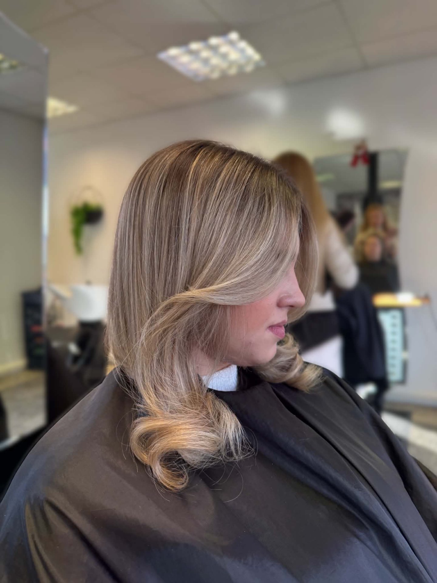 Blonde side-swept blow dry with curled ends